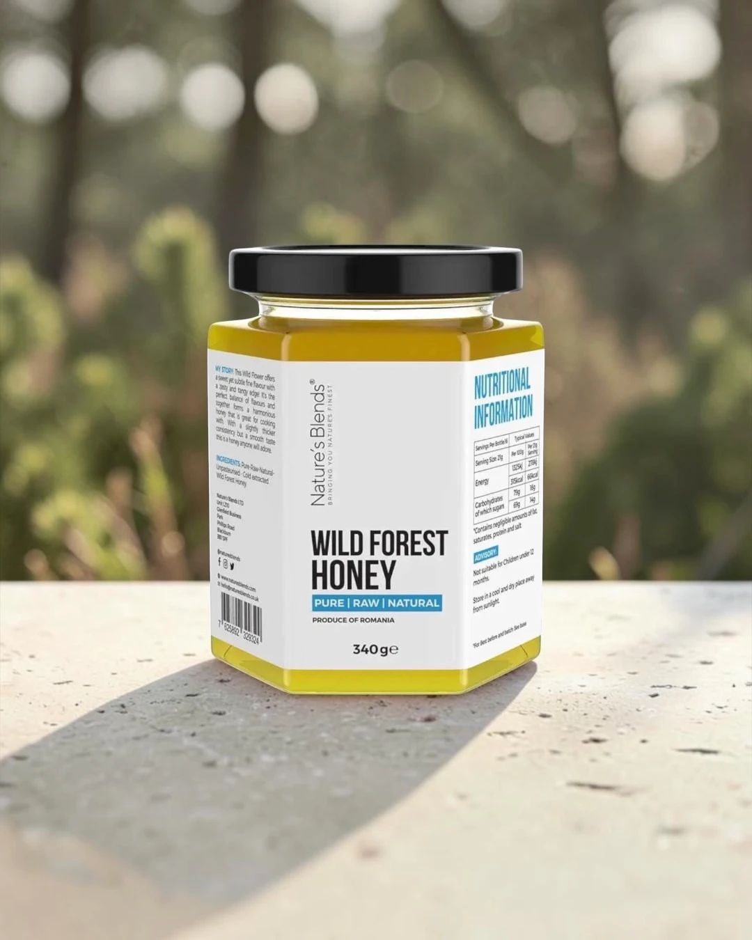 A jar of Nature's Blends Wild Forest Honey on a stone ledge in soft sunlight