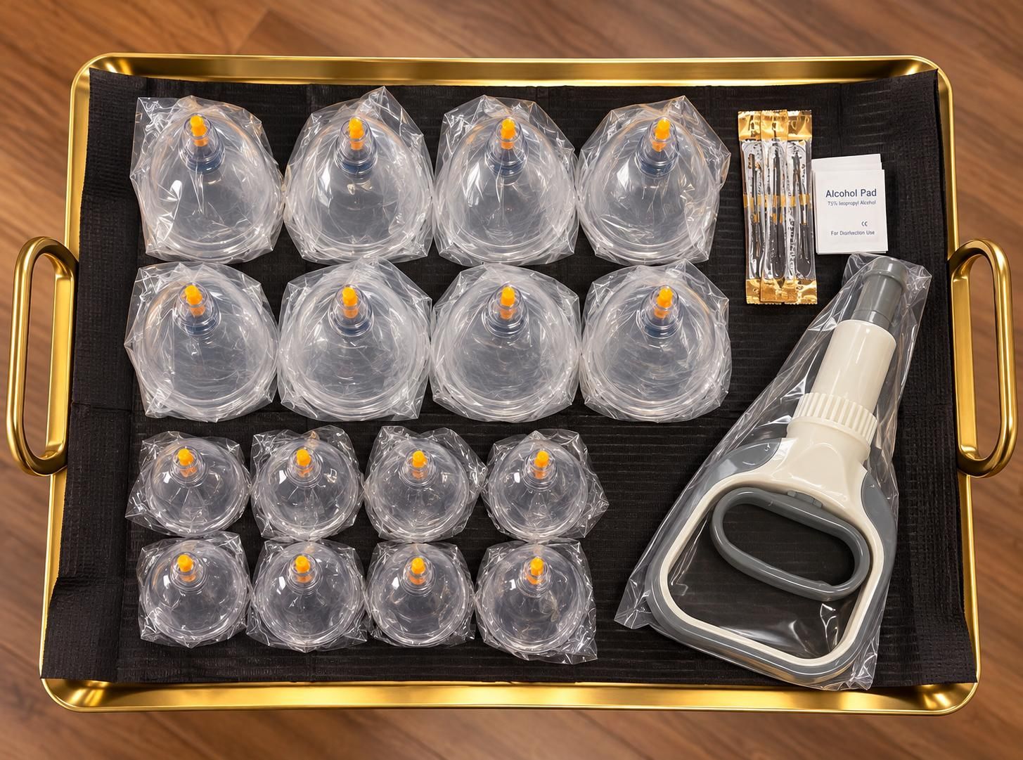 A gold tray set for one session: sealed single-use cups, a sealed pump, sterile lancets and alcohol pads