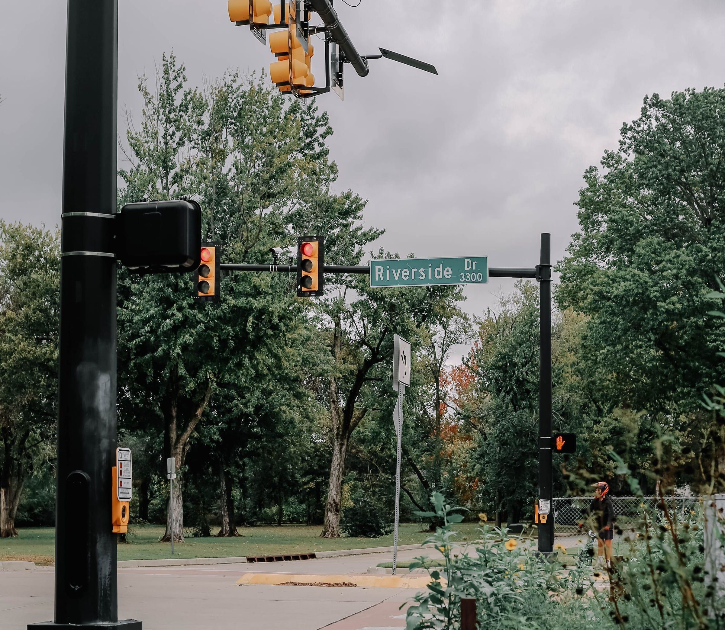Traffic lights and the Riverside Drive street sign among trees in Tulsa, Oklahoma